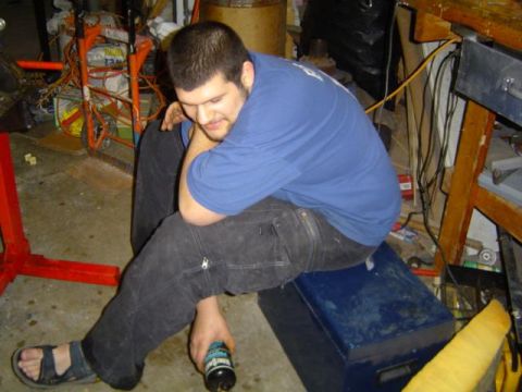 1979 Ford Bronco - Man takes a break in a garage filled with tools and equipment.