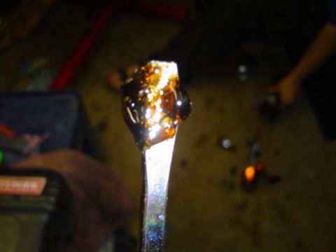 1979 Ford Bronco - A close-up of greasy residue on a tool, with a workshop environment visible in the background.