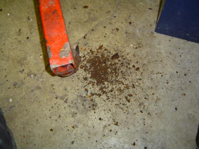 orange jack leg and pile of rust flakes on concrete floor