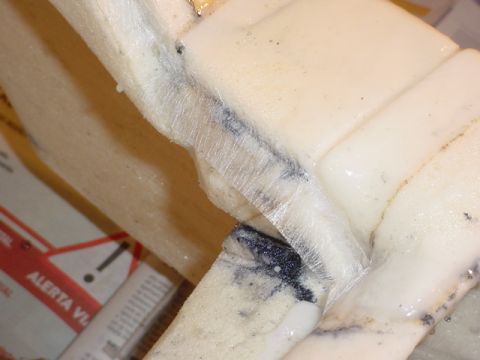 1986 Ford Bronco - This image shows a close-up view of foam padding, possibly from a vehicle's interior, with visible tape and some staining.