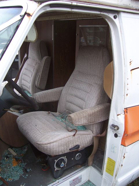 1978 Ford Bronco - Van interior with broken glass on the floor and seats. The album claims it is a 1978 Ford Bronco, but this is incorrect.
