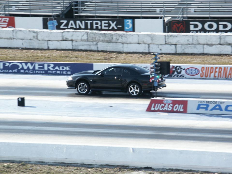 Black New Edge Ford Mustang staged at the christmas tree on a drag strip