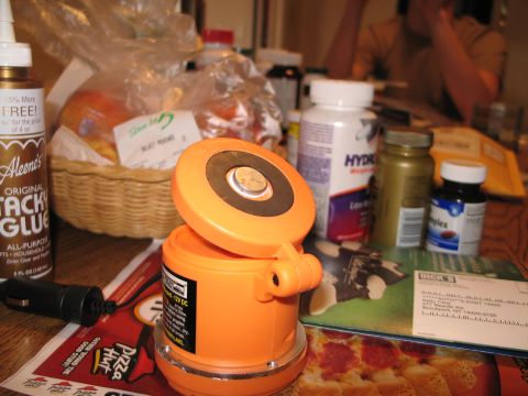 1995 Ford Bronco - An orange magnetic light sits on a table with other items, including glue, fruit, and pill bottles.