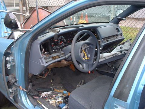 1999 Ford Crown Victoria - The interior of a car is shown with the dashboard disassembled and wiring exposed.
