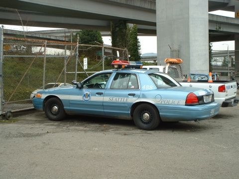 1999 Ford Crown Victoria - A Seattle Police Department Ford Crown Victoria is parked next to a white pickup truck under an overpass.