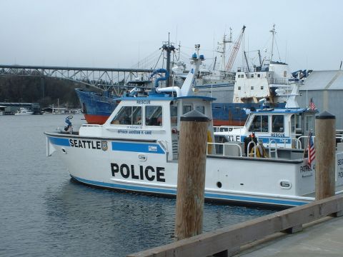 1999 Ford Crown Victoria - Two Seattle police boats are docked at a harbor with a bridge in the background.