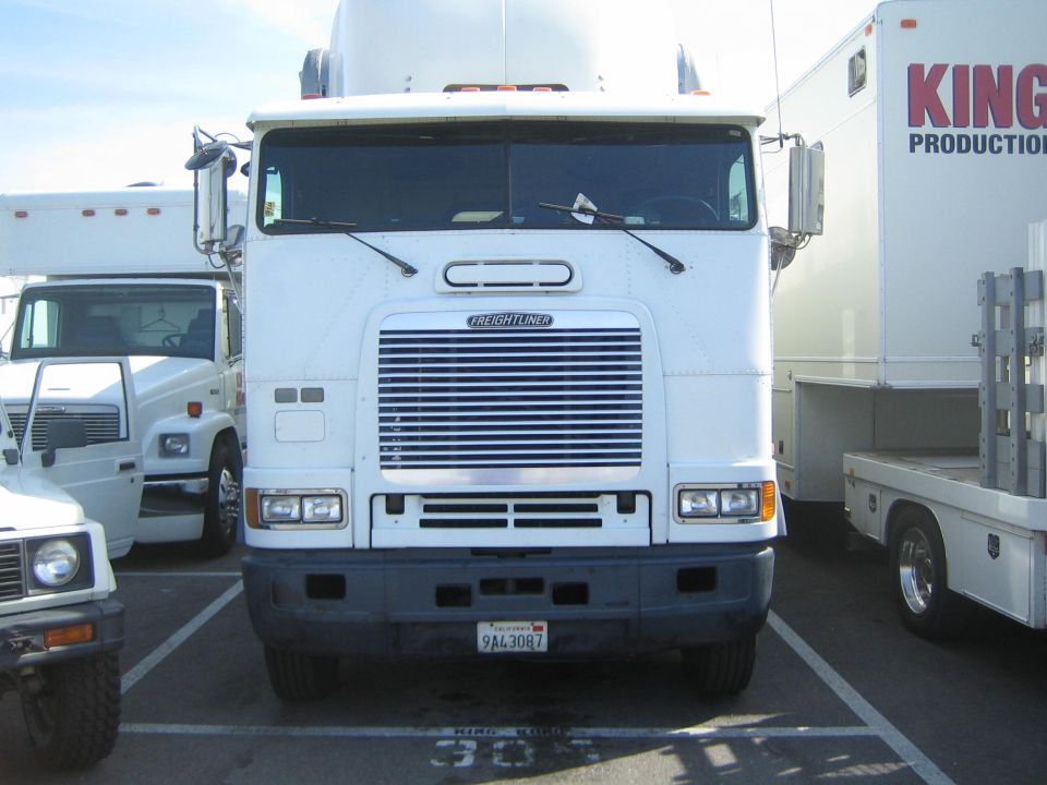 White Freightliner cabover semi truck front view parked in a lot, plate 9A43087
