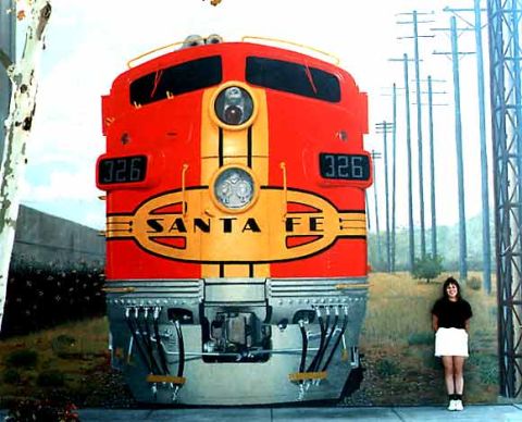 1978 Ford Bronco - A woman poses next to a Santa Fe train engine, which is painted red and yellow with the number 326 visible.