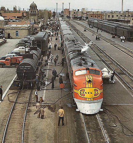1978 Ford Bronco - A Santa Fe train is being refueled at a busy station, with several cars and people visible.