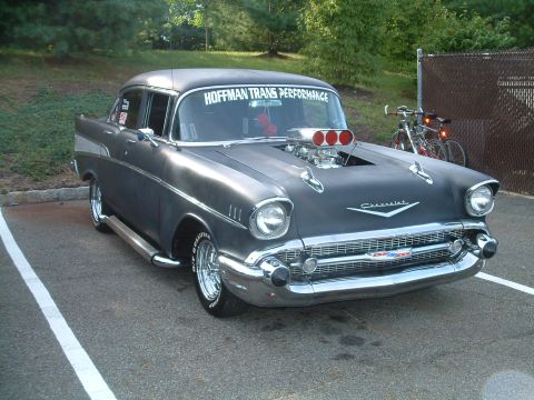1994 Ford Bronco - A modified 1957 Chevrolet Bel Air with a large engine intake is parked outdoors.