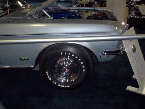 1970 Ford Ranchero - A silver 1970 Ford Ranchero GT is displayed with its hood open, revealing the engine and wide oval tires.