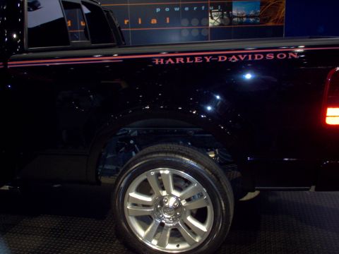1970 Ford Ranchero - Side view of a black pickup truck with Harley-Davidson graphics and chrome wheels.