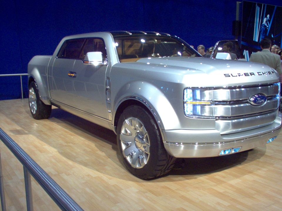 Silver Ford Super Chief concept truck on an auto show stage, three-quarter front view