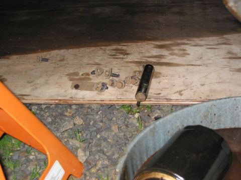 1991 Ford Explorer - A collection of bolts and a tool are placed on a wooden surface, possibly during a vehicle maintenance task.