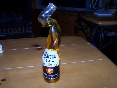 1979 Ford F-150 - A Corona Extra bottle appears to be bent in the middle, with its top section angled upwards.