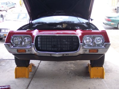 1972 Ford Ranchero - Front view of a 1972 Ford Ranchero with its hood up, elevated on jack stands.