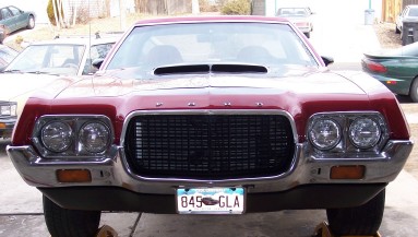 1972 Ford Ranchero - The front of a red 1972 Ford Ranchero is shown, with a prominent grille and headlights.