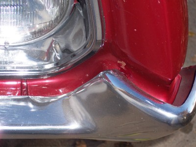 1972 Ford Ranchero - Detail of a red vehicle's front end, focusing on the bumper and headlight area.