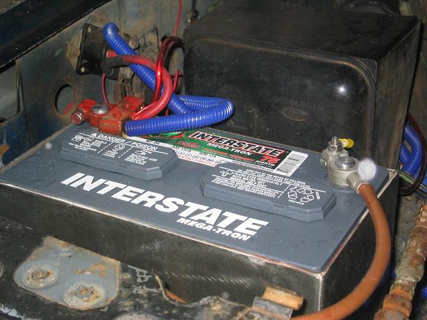 Interstate Mega-Tron battery in engine bay with red terminal cover and blue wire loom