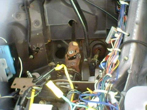 1994 Ford Bronco - Close-up of the steering column and a complex wiring harness within a vehicle's interior.