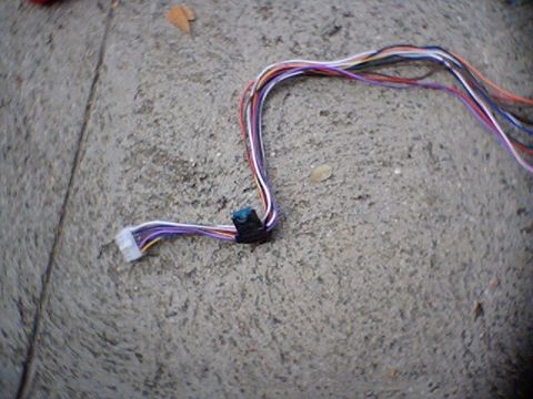 1994 Ford Bronco - Wiring harness with a white connector and multiple colored wires is visible on a concrete surface.