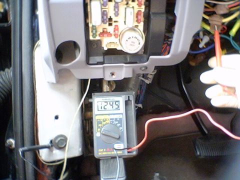 1994 Ford Bronco - Multimeter connected to vehicle fuse box, showing 12.45 volts.