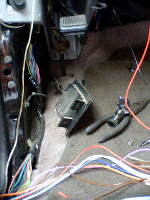 1994 Ford Bronco - Exposed wiring and a black plastic component are visible on the floor of a vehicle's interior.
