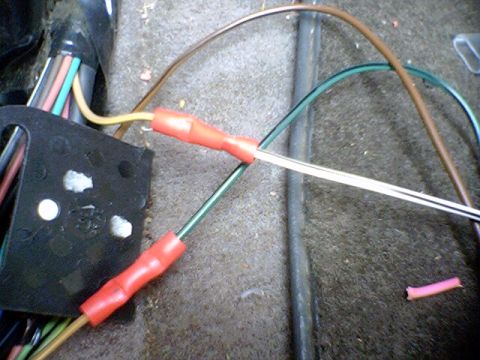 1994 Ford Bronco - Close-up of a vehicle's wiring harness showing red crimp connectors and multiple wires.
