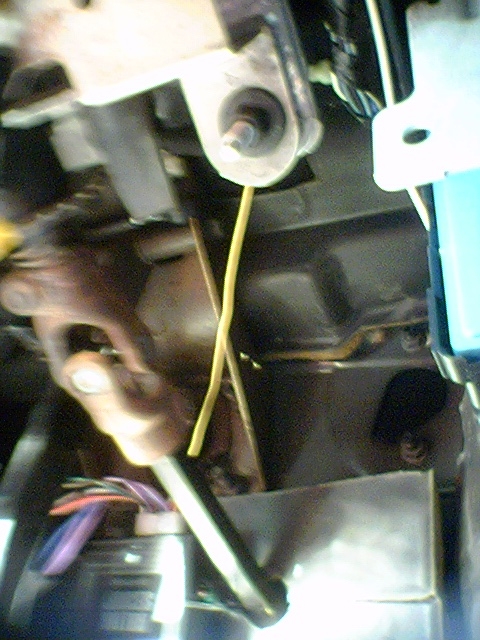 1994 Ford Bronco - Detail of wiring harness and a yellow wire visible under the dashboard of a vehicle.