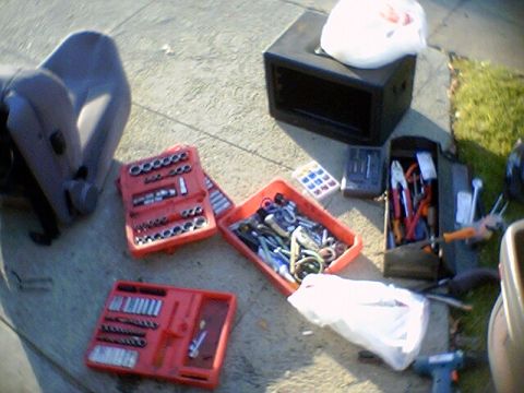 1994 Ford Bronco - Tools and a car seat are laid out on the ground, possibly for repair or cleaning.