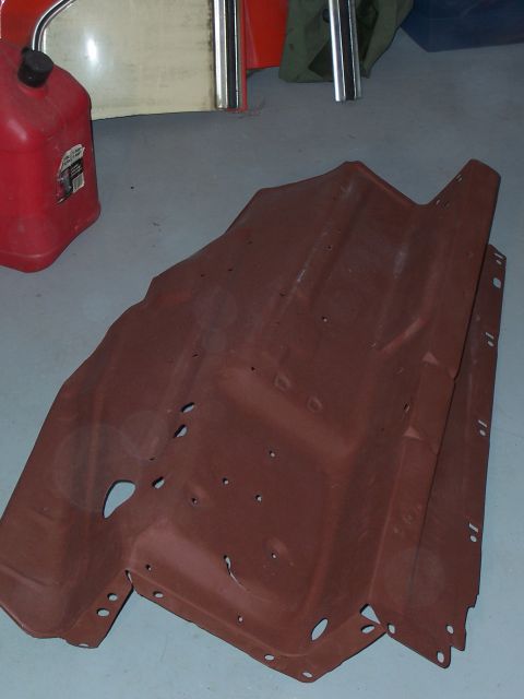1978 Ford Bronco - A rusty metal car part is shown in a garage setting with a red gas can nearby.