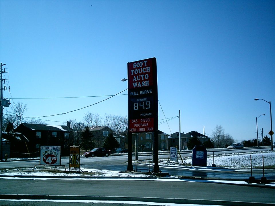 Dark sedan parked near a gas station sign
