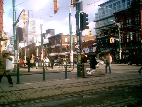 1997 Ford Escort - A busy street scene in Toronto, Canada, with pedestrians crossing the street and buildings lining the road.