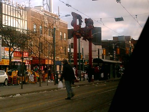 1997 Ford Escort - A street scene shows construction equipment and a pedestrian crossing the road in front of buildings.