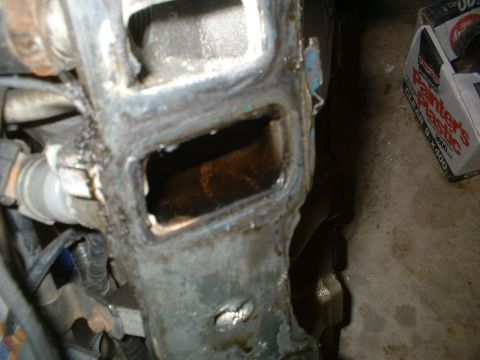 1993 Ford Bronco - This image shows a close-up view of a damaged engine component, likely an intake manifold or cylinder head, with a failed gasket seal.
