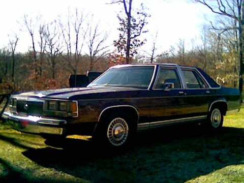 1991 Ford Crown Victoria LTD - This sedan has a boxy body style with chrome accents on the windows and trim.