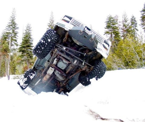1986 Ford Bronco - This vehicle appears to be stuck in a snowy environment, tilted on its side.