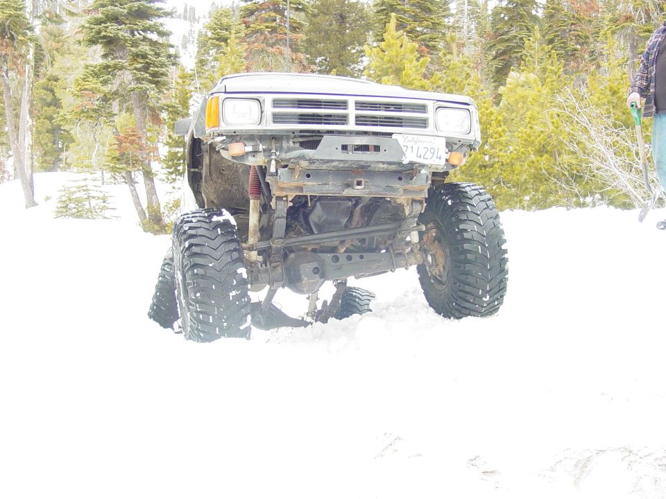 Lifted truck with large tires stuck in snow, front view