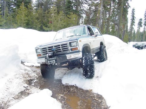 1986 Ford Bronco - This Ford Bronco navigates a challenging snowy path, its off-road capabilities.