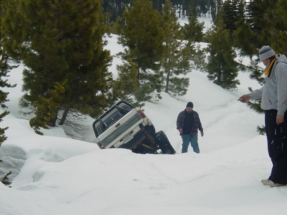 White pickup truck stuck in a snow drift, rear view