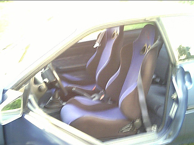 Interior view of a car with aftermarket racing seats and a manual shifter