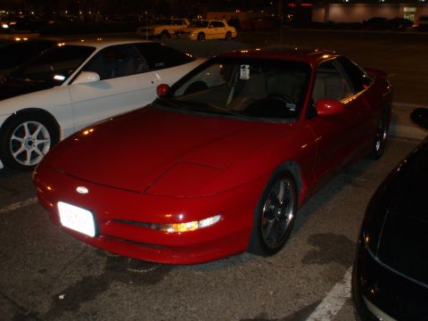 1997 Ford Probe - A red Ford Probe is parked in a lot at night, with other vehicles visible.