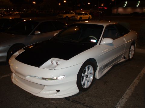 1997 Ford Probe - A white Ford Probe with a black hood and custom body kit is seen at a nighttime gathering.