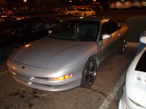 1997 Ford Probe - A silver 1997 Ford Probe is parked at night, with other vehicles visible in the background.
