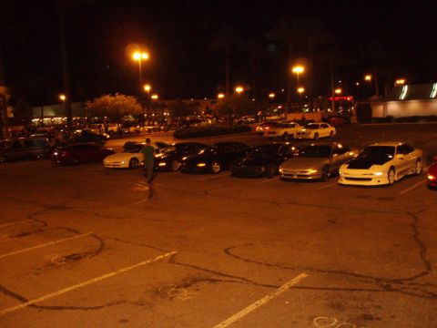 1997 Ford Probe - A nighttime gathering of cars in a parking lot, with multiple vehicles visible.