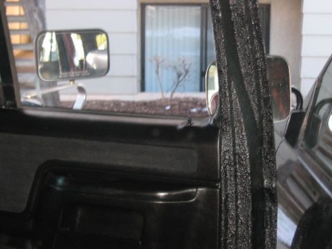 1991 Ford Bronco - Interior view of a vehicle's door panel, showing black plastic and fabric details.
