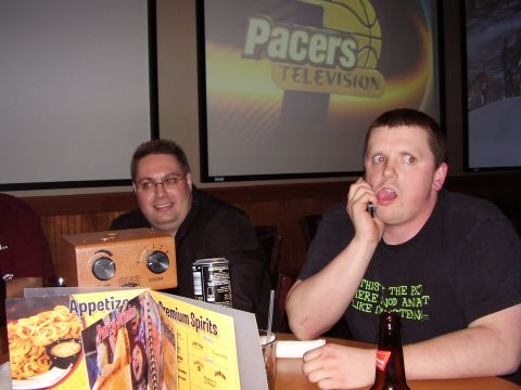 1997 Ford Taurus - Two men are seated at a table, with a projection screen displaying 'Pacers Television' in the background.
