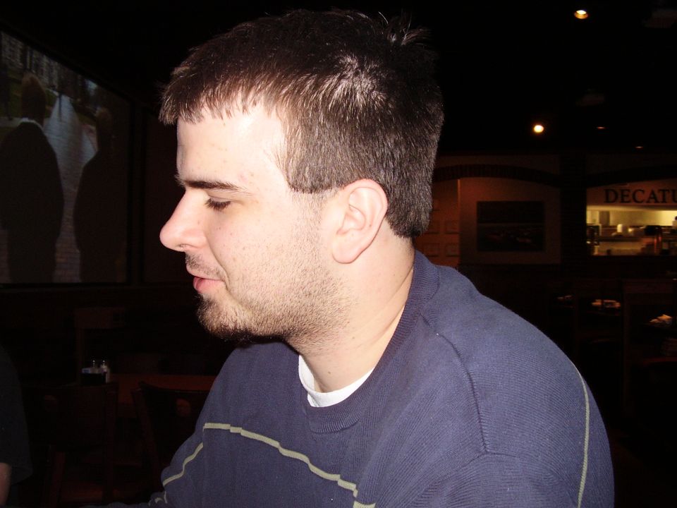 Man in profile wearing a blue sweatshirt with horizontal stripes