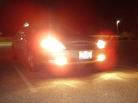 1997 Ford Taurus - A 1997 Ford Taurus is seen from the front at night, its headlights illuminated.