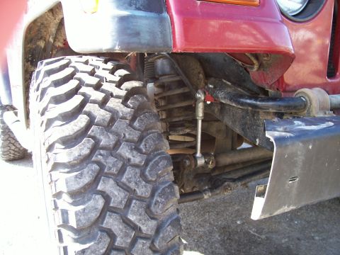 1998 Jeep TJ - This image focuses on the suspension and large off-road tire of a Jeep, highlighting its lifted setup.